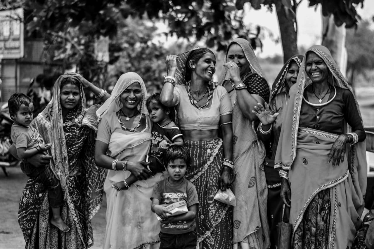 A group of women and children standing together on a village road